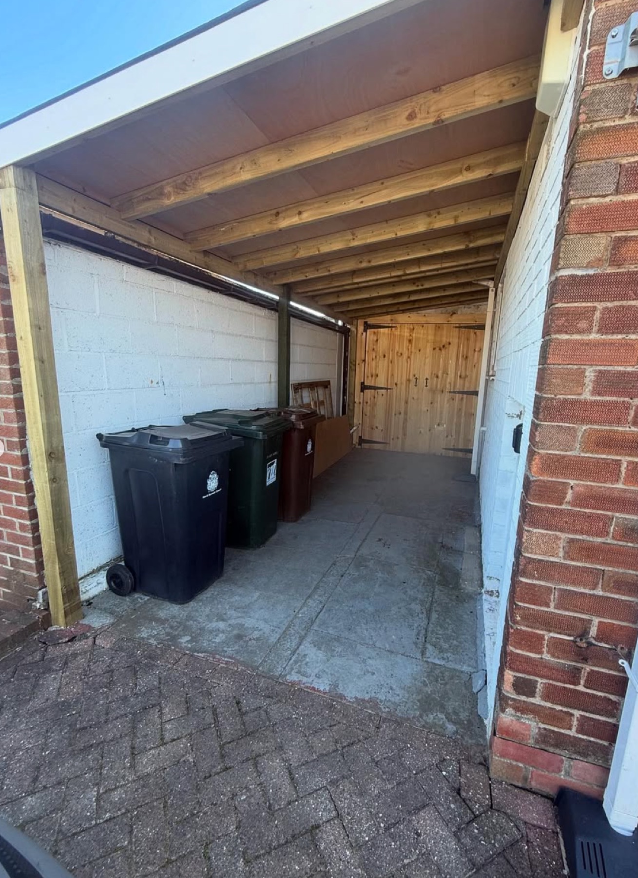 Finished boarded timber canopy roof over a side passage with new doors