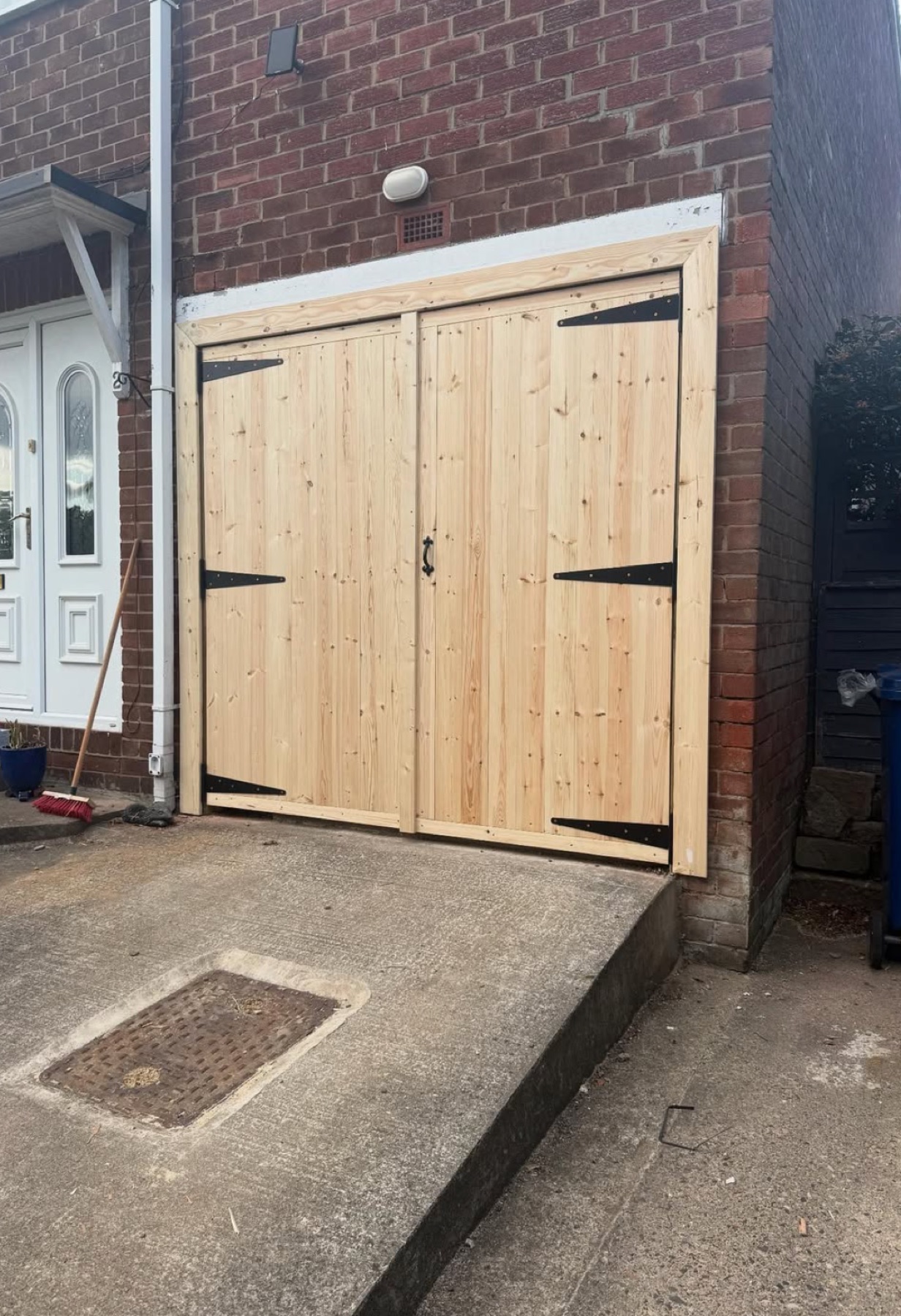 New bespoke timber garage doors with black strap hinges