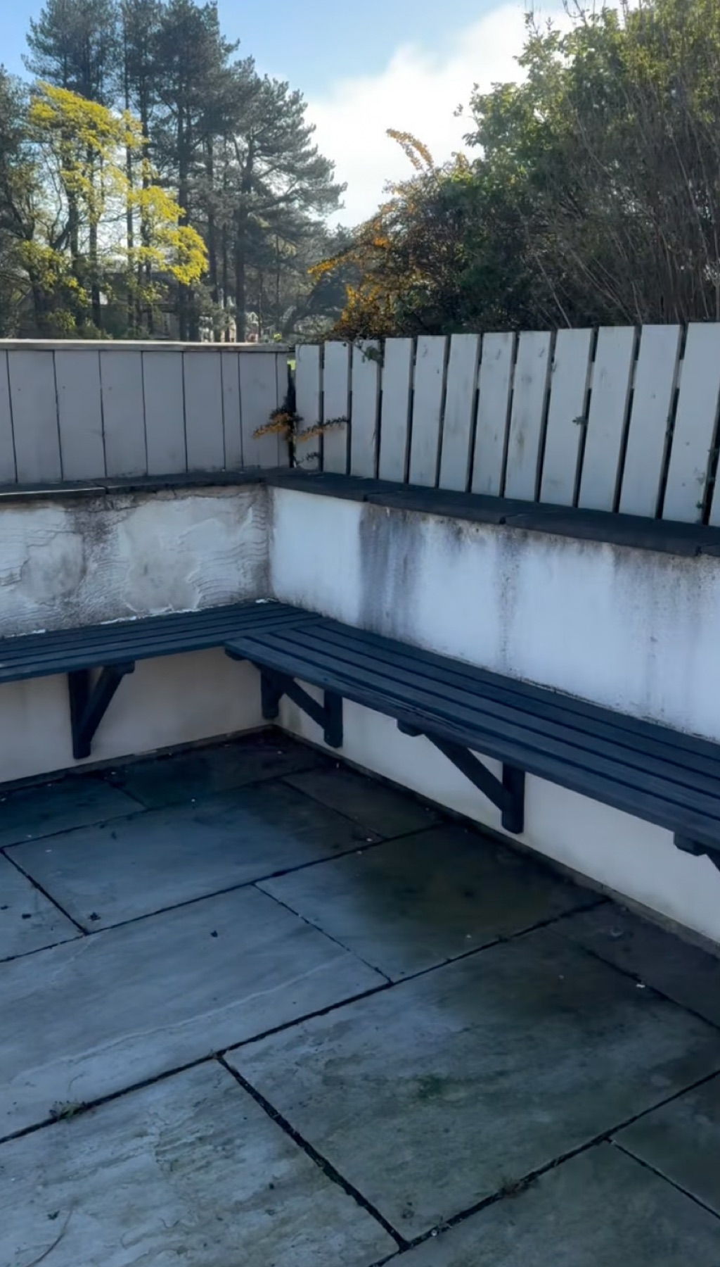 The old weathered painted garden benches and wall before