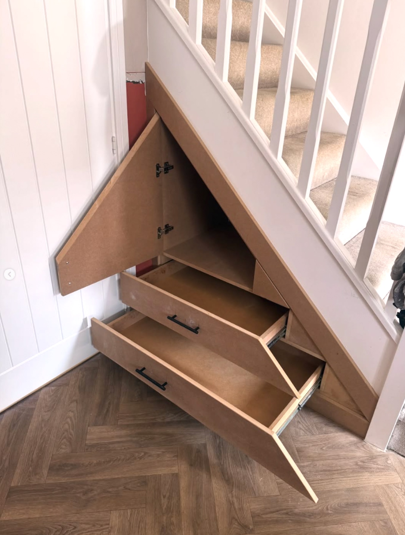 Under-stair storage with pull-out drawers and cupboard open