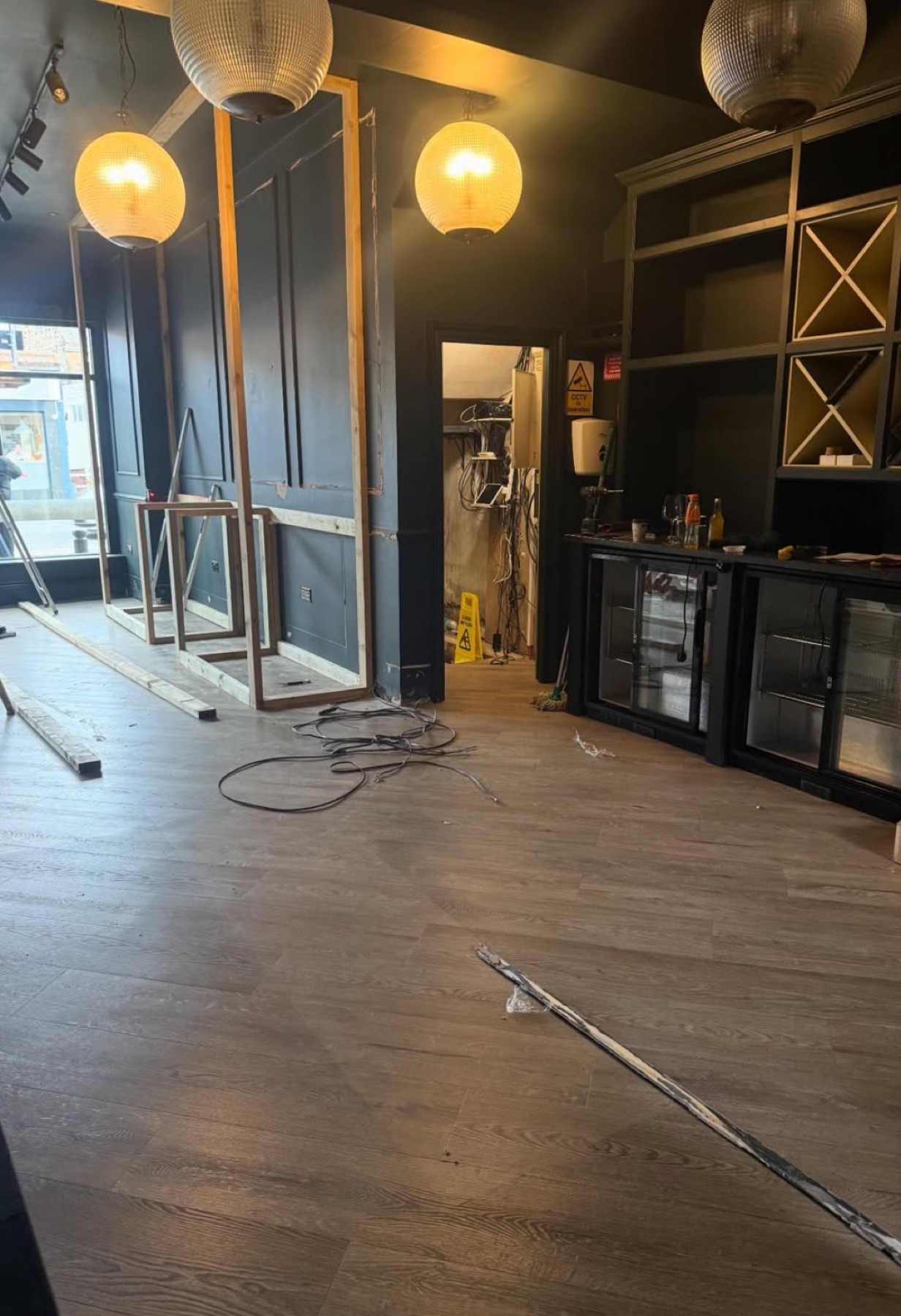 The wine bar mid-refurbishment with panelling part-installed and cables on the floor